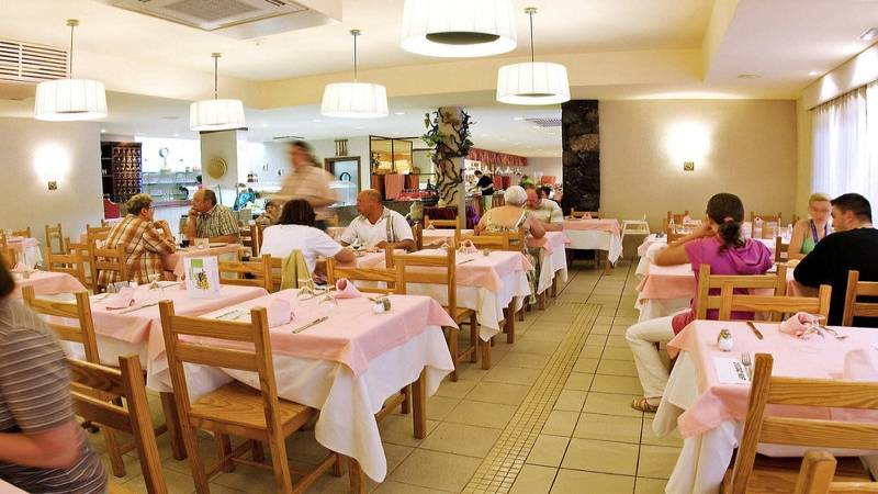 Mehrere Gäste sitzen in einem gepflegten Restaurant des Aparthotel Costa Mar.