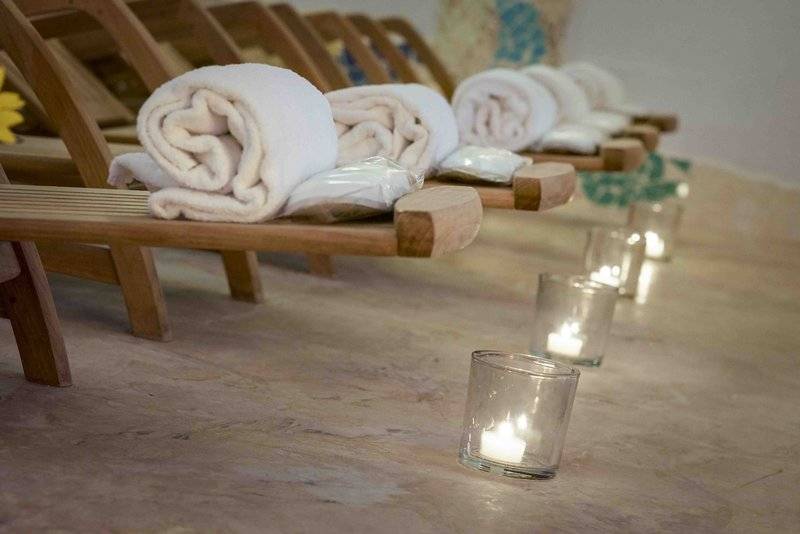 Reihe von Lounge-Stühlen mit Handtüchern und brennenden Kerzen im Grand Hotel Poltu Quatu.