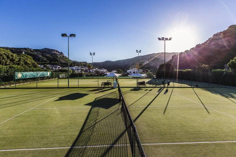 Tennisplatz des Grand Hotel Poltu Quatu mit grünem Spielfeld und Sonnenschein.