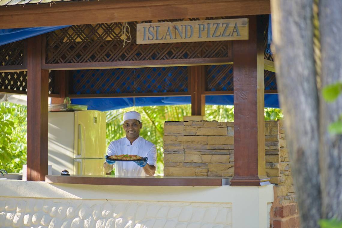 Koch im Sun Siyam Olhuveli Hotel präsentiert eine Pizza am Island Pizza Stand.