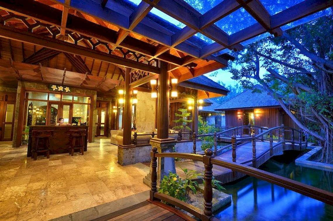 Außenansicht des Sun Siyam Olhuveli Hotels bei Nacht mit Beleuchtung und Wasser