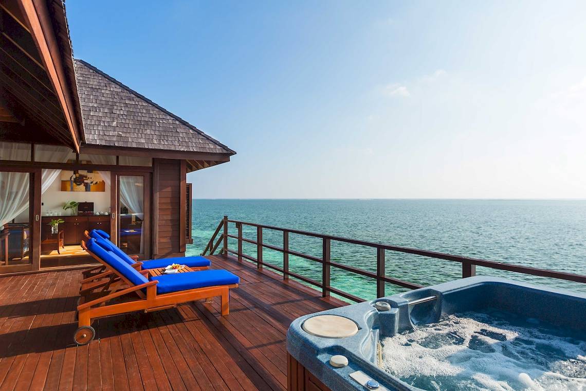 Ein Balkon des Sun Siyam Olhuveli Hotels mit Jacuzzi und Meerblick.