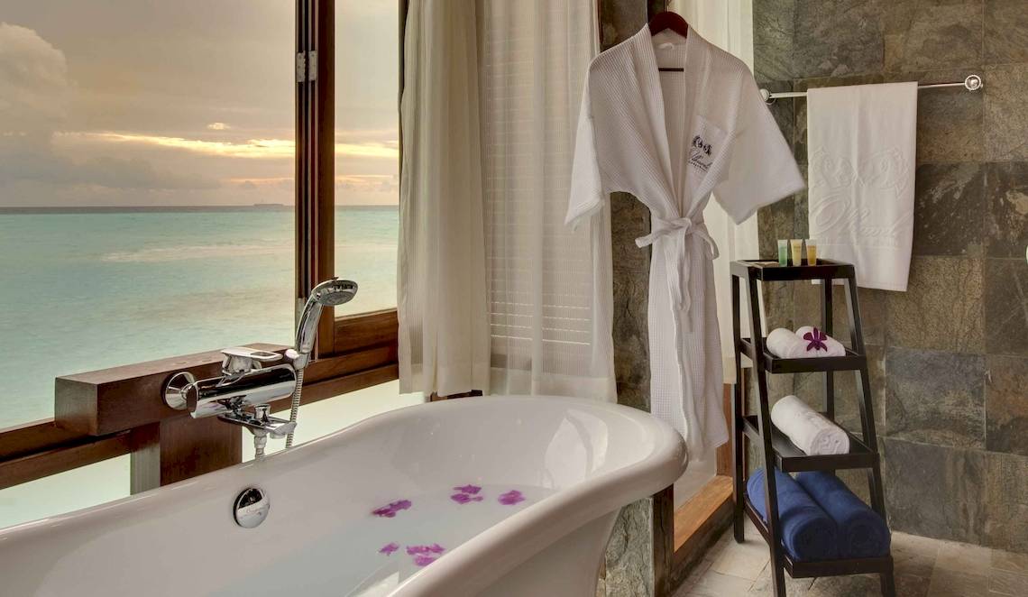 Badezimmer mit Blick auf das Meer und einem weißen Bademantel