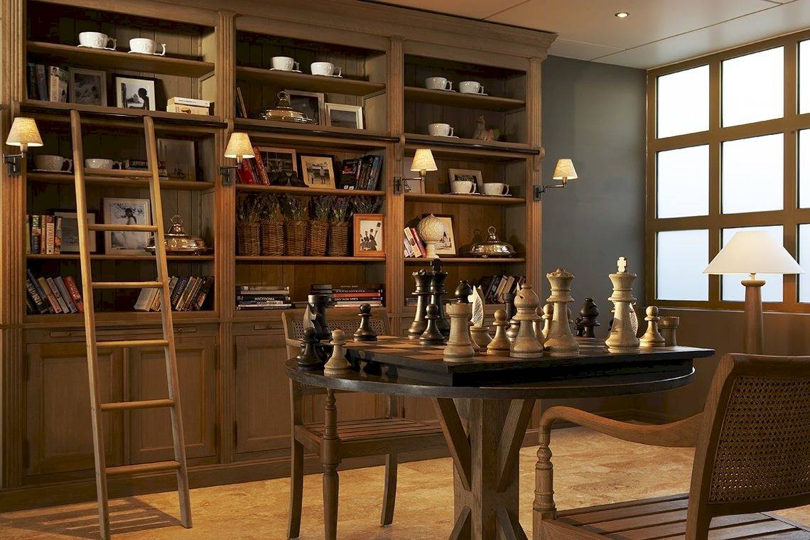 Eine Holzbibliothek mit Regalen, einem Schachbrett auf dem Tisch und einem Stuhl davor.