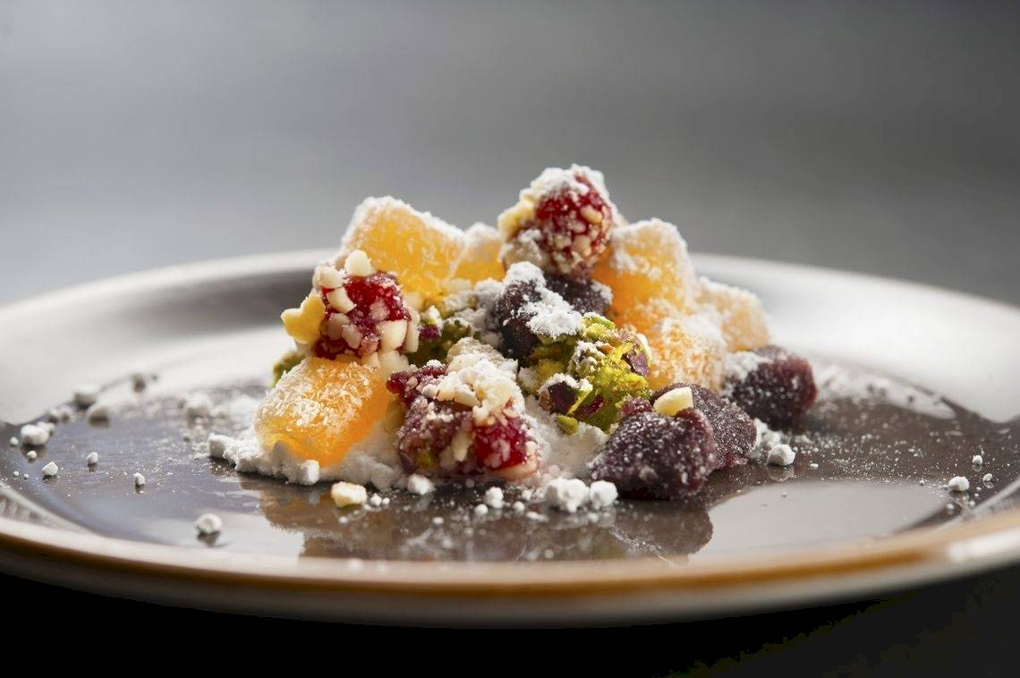 Obstsalat auf einem weißen Teller mit goldfarbenem Rand.