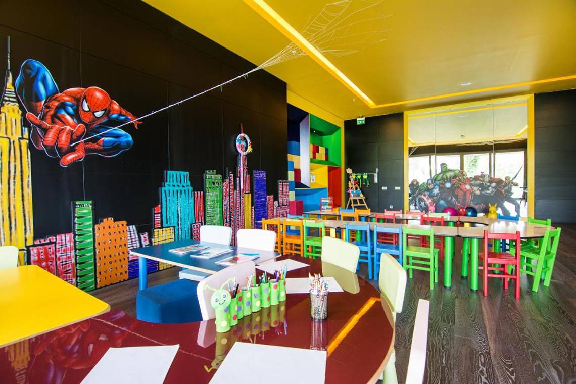 Foto des Kinderzimmers im Akra Hotel mit Superhelden-Wandgestaltung und bunten Möbeln.