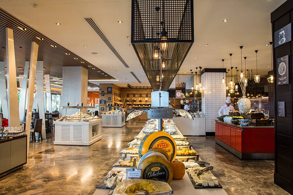 Buffetbereich im Akra Hotel mit verschiedenen Käsesorten und Speisen.