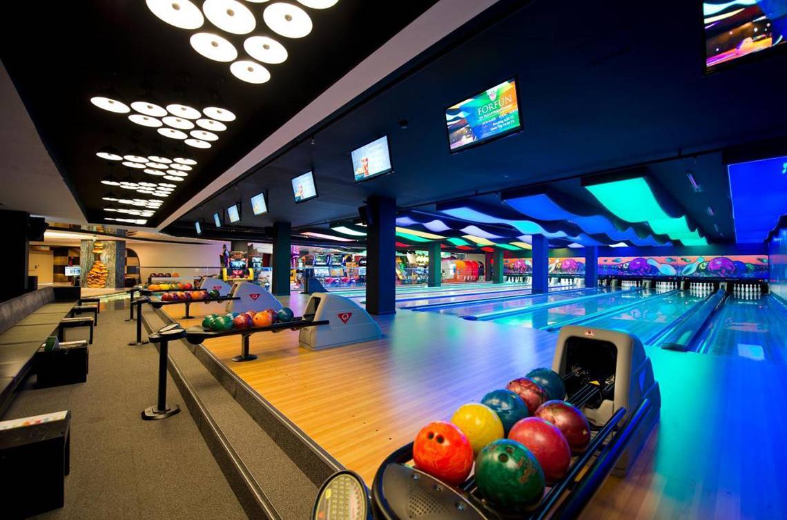 Bowlinghalle im Akra Hotel mit leuchtenden Farben und Bowlingbahnen.