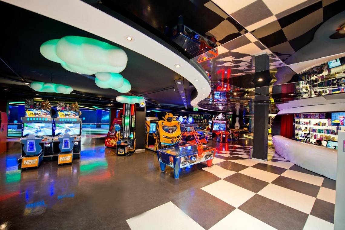 Innenansicht der Spielhalle im Akra Hotel mit verschiedenen Arcade-Spielen und einer gemusterten Bodenfläche.