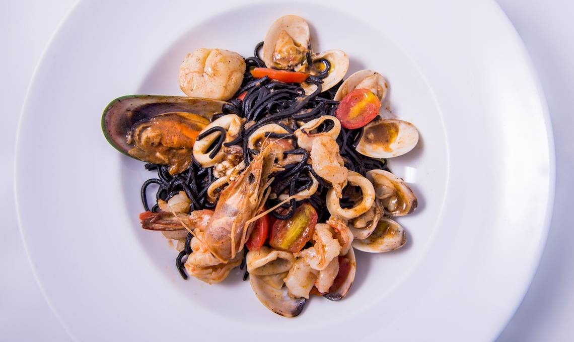 Gerichteteller Teller mit schwarzen Spaghetti, Garnelen, Tintenfisch und Muscheln auf dem Dusit Thani Laguna Phuket