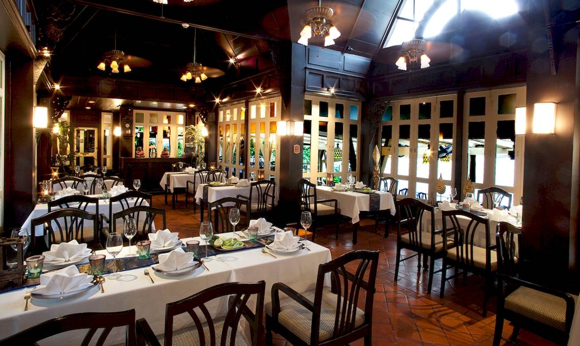 Innenansicht des Restaurants des Dusit Thani Laguna Phuket mit gedeckten Tischen und Stühlen.