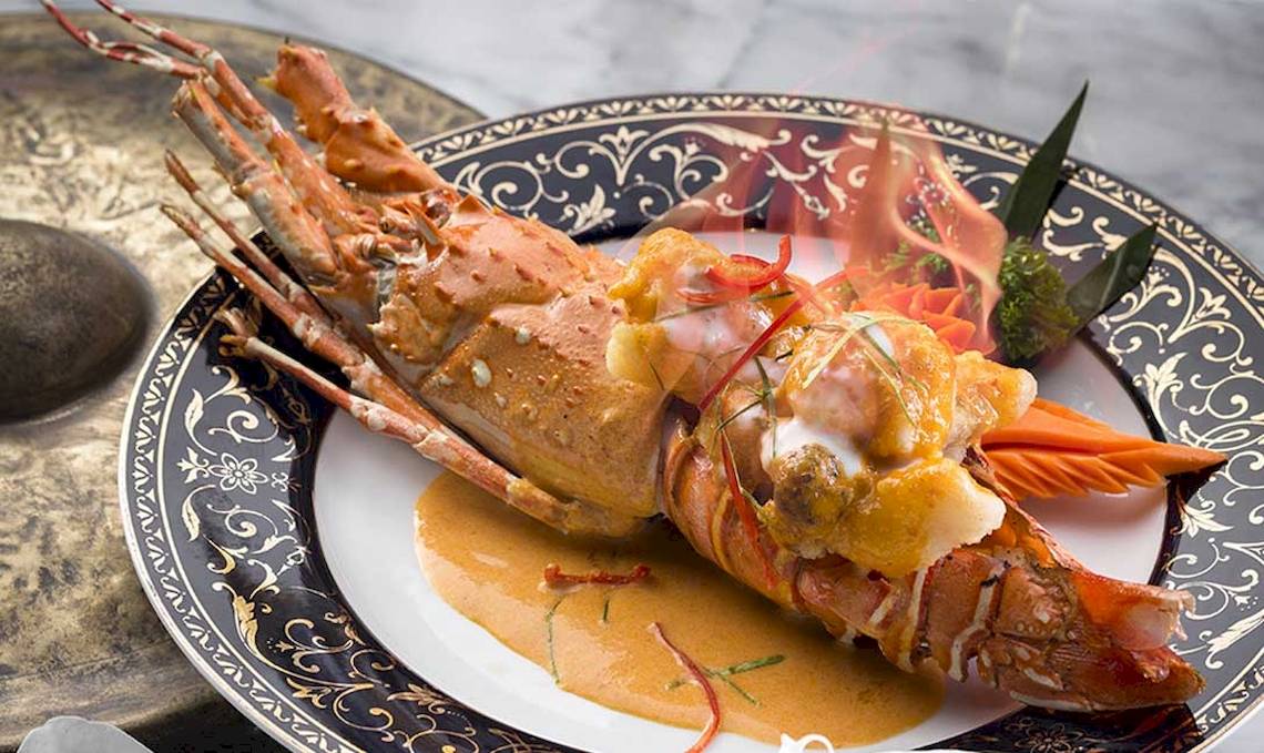 Gebratene Garnelen mit Sauce auf einem festlich dekorierten Teller im Dusit Thani Laguna Phuket