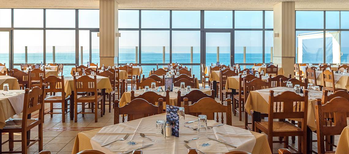 Innenansicht des Restaurants im Themis Beach Hotel mit Blick auf das Meer.