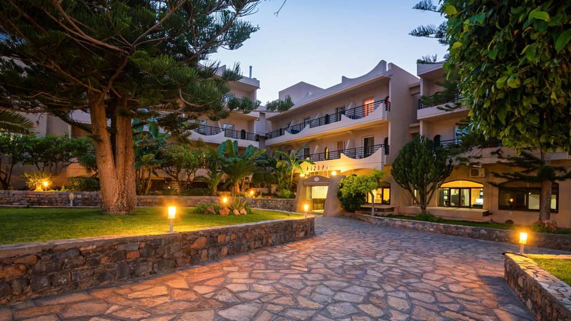 Der Eingangsbereich des Themis Beach Hotels bei Nacht mit Steinweg und Beleuchtung.