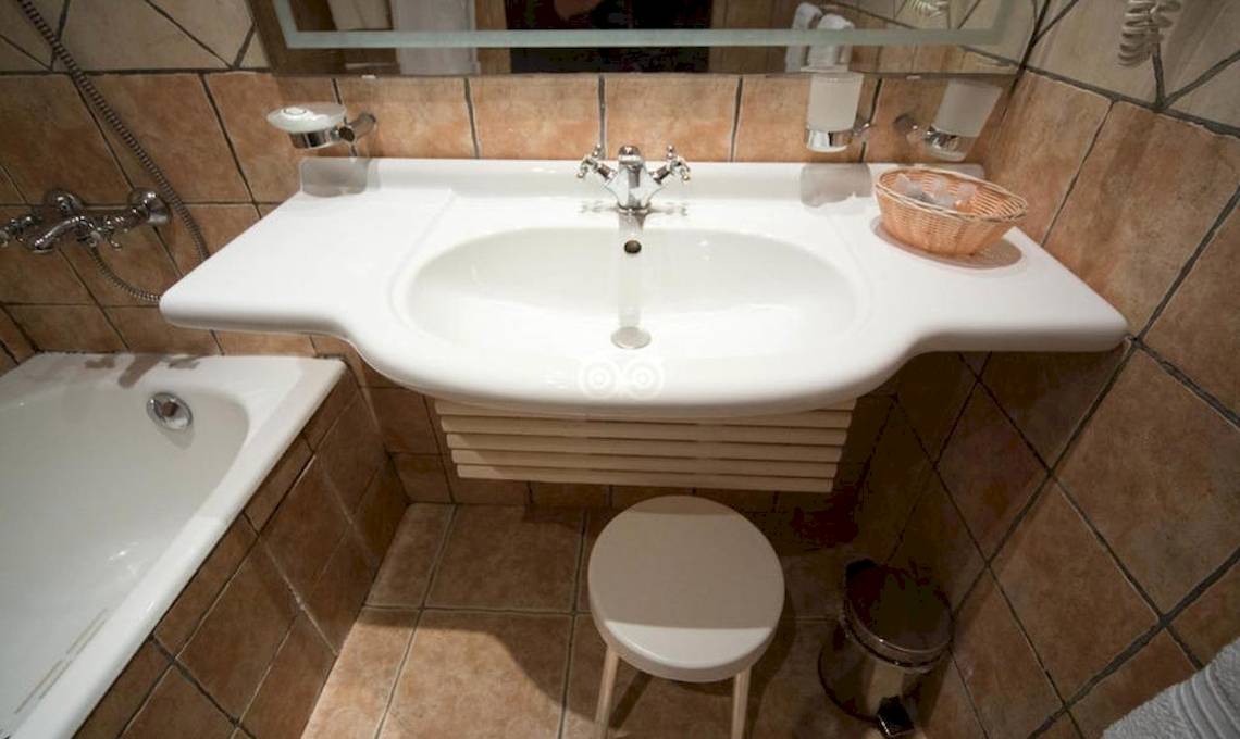 Badezimmer mit Badewanne, Waschbecken, Spiegel und Ablage