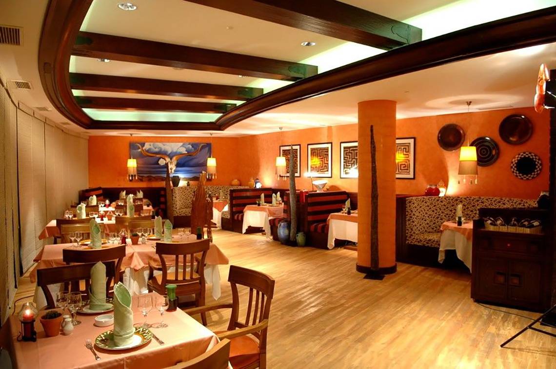 Innenansicht des Restaurants im Calista Luxury Resort mit gedeckten Tischen und dekorativen Elementen.