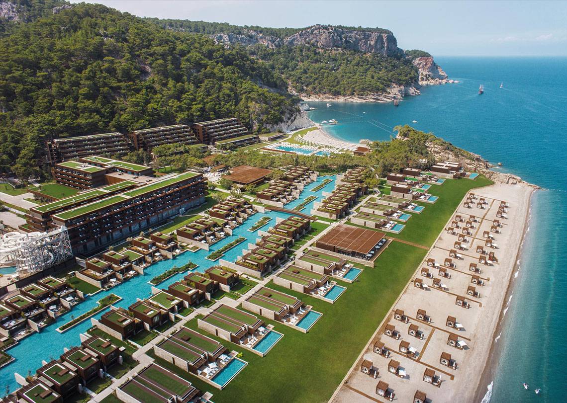 Luftaufnahme des Maxx Royal Kemer Resorts mit Pools, Gebäuden und Klippen am Meer