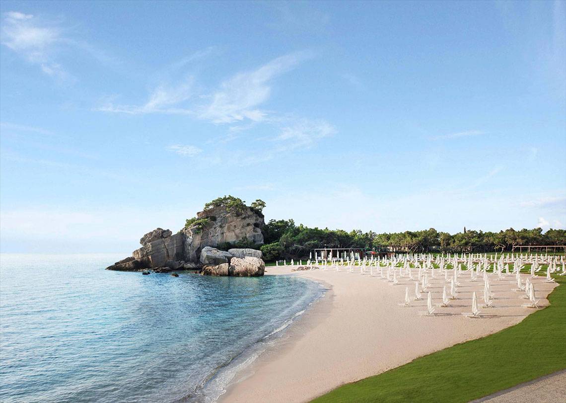 Maxx Royal Kemer Resort Strand mit vielen weißen Sonnenschirmen und blauem Wasser
