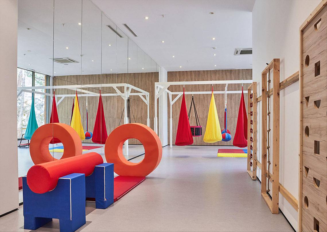 Innenbereich des Maxx Royal Kemer Resorts mit bunten Spielgeräten und Hängesesseln.