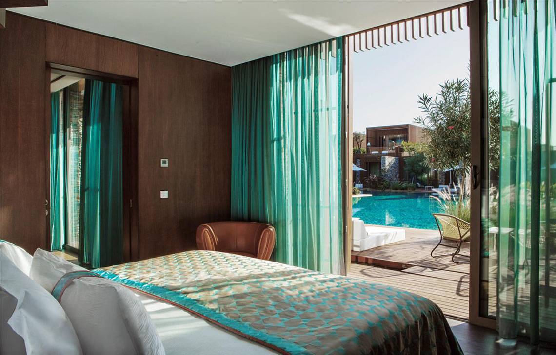 Schlafzimmer im Maxx Royal Kemer Resort mit Blick auf einen Swimmingpool und eine Terrasse.