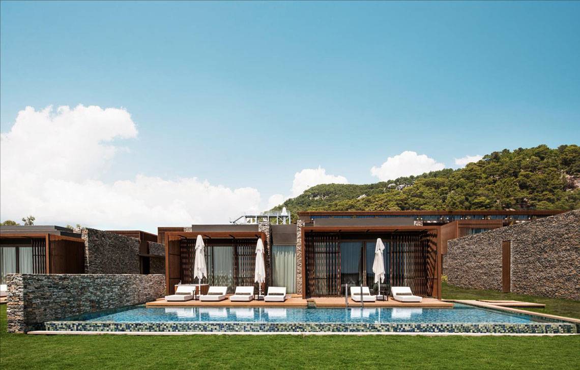 Außenbereich des Maxx Royal Kemer Resort mit Swimmingpool, Loungestühlen und Sonnenschirmen.