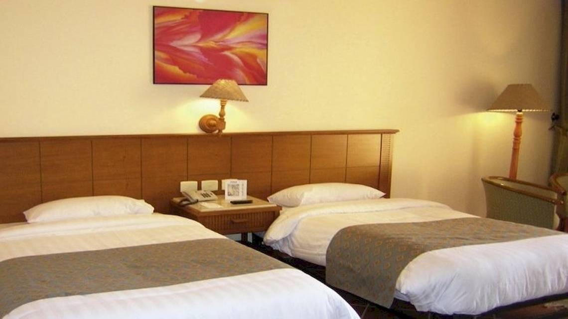 Doppelbettzimmer im Charmillion Garden Aqua Park Hotel mit zwei Betten, Nachttischen und Lampen.