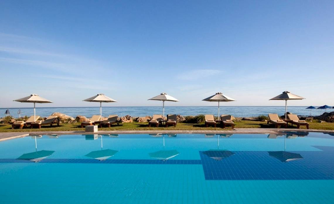 Aquila Rithymna Beach Hotel Pool mit Sonnenliegen und Meerblick