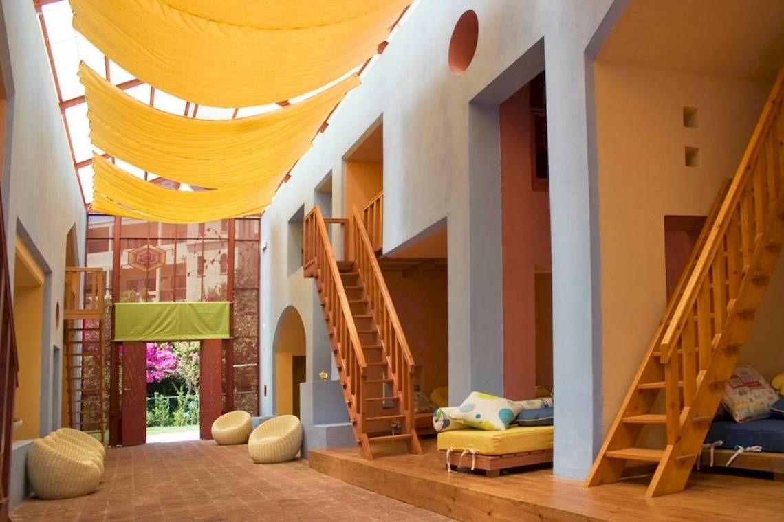 Innenbereich des Aquila Rithymna Beach Hotels mit gelben Vorhängen und Holztreppen.