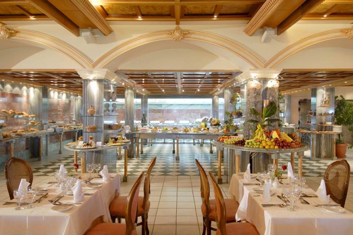 Frühstücksbuffet im Aquila Rithymna Beach Hotel mit verschiedenen Früchten und Speisen.