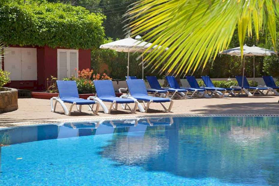 Außenpool des HSM Venus Playa Hotels mit blauen Liegestühlen und Sonnenschirmen.