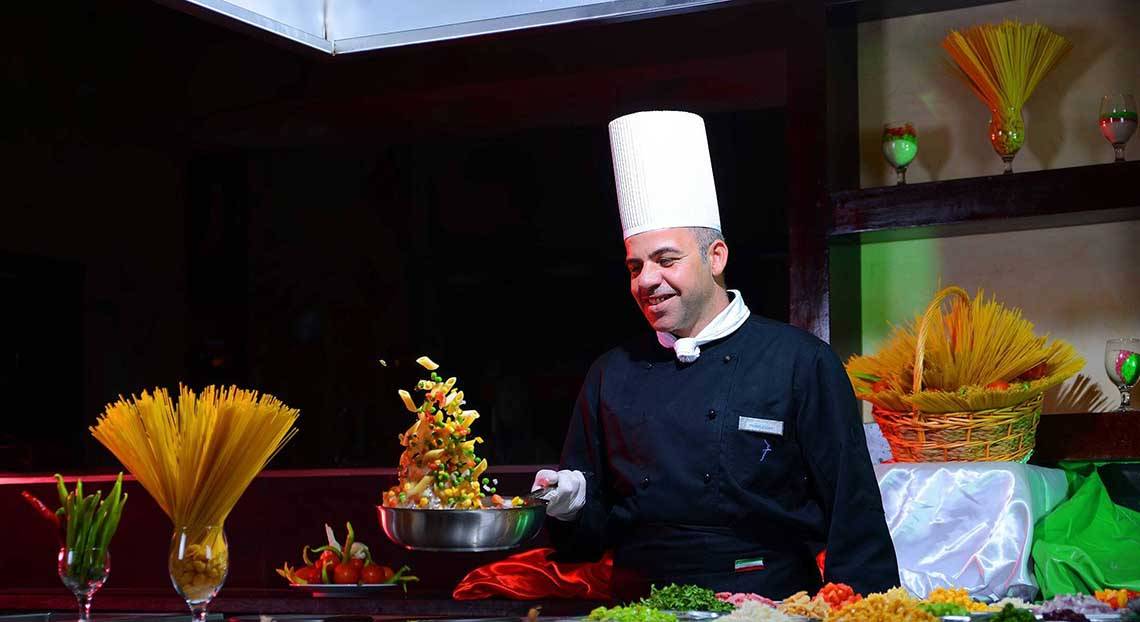 Koch beim Pickalbatros Jungle Aqua Park Resort serviert Gemüse auf einem Buffet.