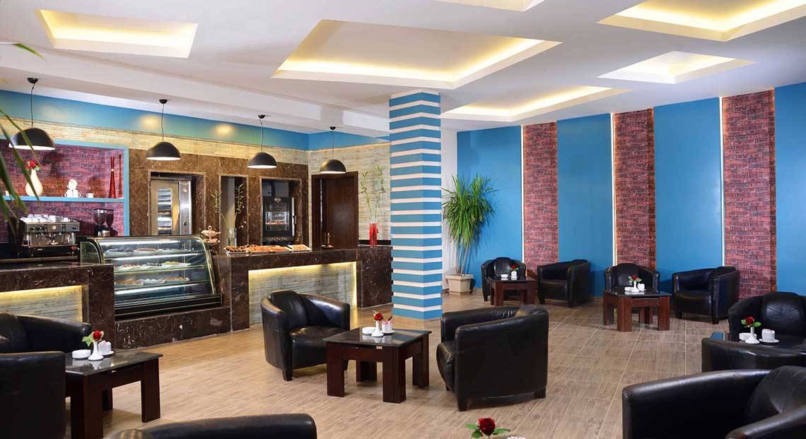 Lobby des Pickalbatros Jungle Aqua Park Resorts mit schwarzen Ledersesseln und einem blau-weiß gestreiften Design.