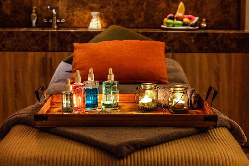 Massagetisch im Crystal Springs Beach Hotel mit Flaschen und Kerzen