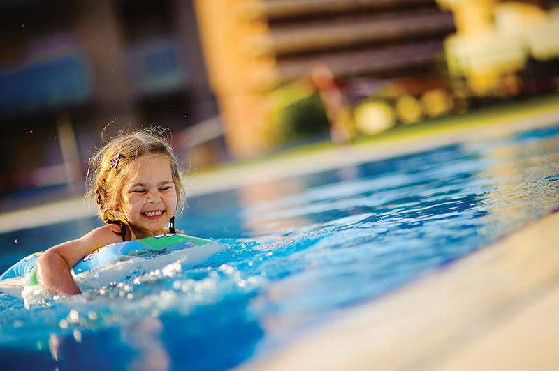 Ein junges Mädchen schwimmt im Pool des Crystal Springs Beach Hotels.