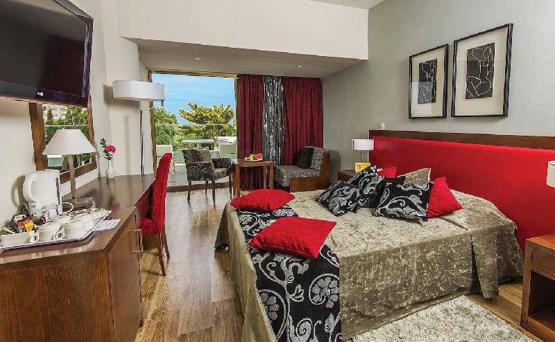 Innenansicht eines Zimmers im Crystal Springs Beach Hotel mit einem großen Bett, Dekor und Möbeln.