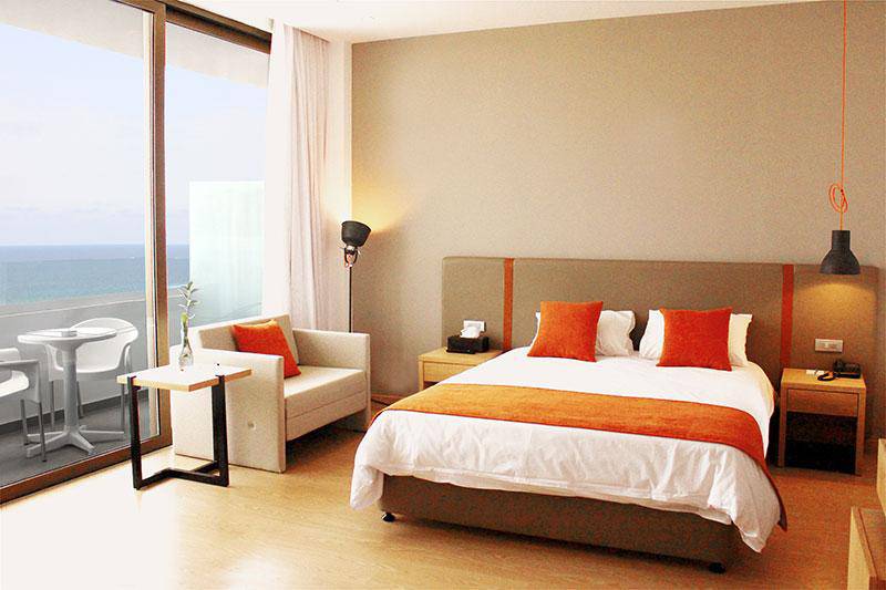 Schlafzimmer mit Meerblick im Crystal Springs Beach Hotel mit Bett, Couch und Tisch.