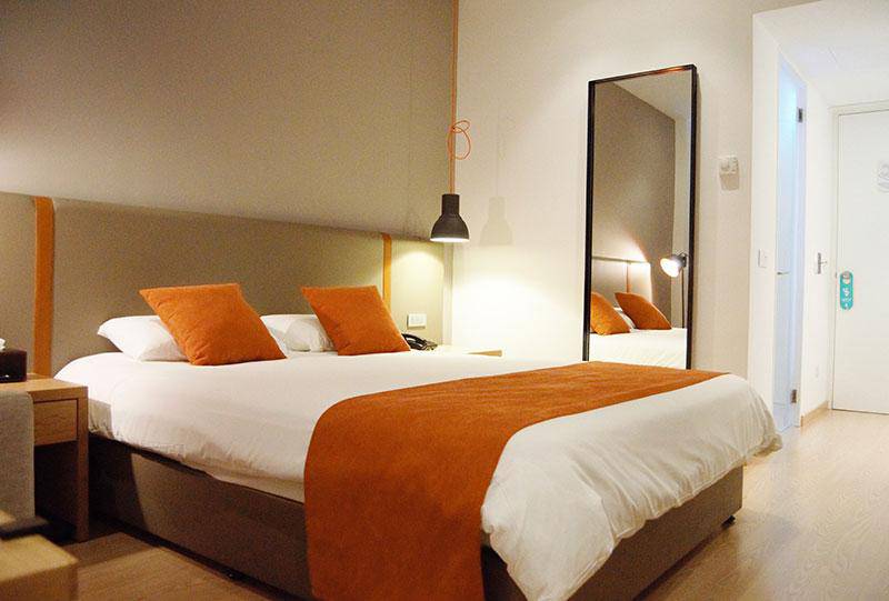 Schlafzimmer im Crystal Springs Beach Hotel mit Bett, Kissen und Spiegel