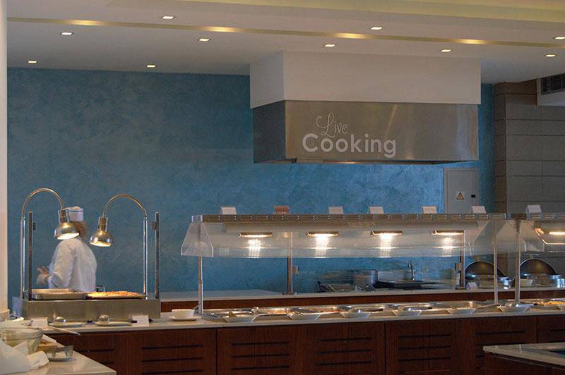 Live Cooking Bereich im Crystal Springs Beach Hotel mit Küchenutensilien und einem Koch.