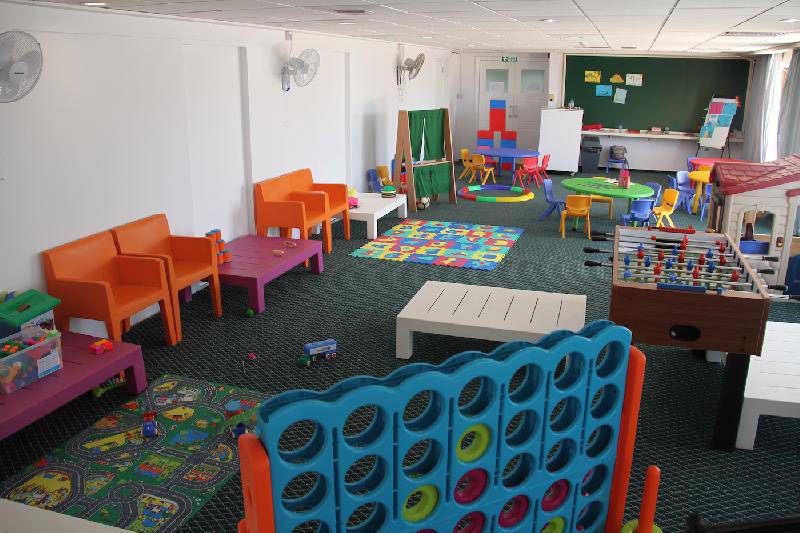 Kinderspielzimmer im Crystal Springs Beach Hotel mit bunten Möbeln und Spielzeug.