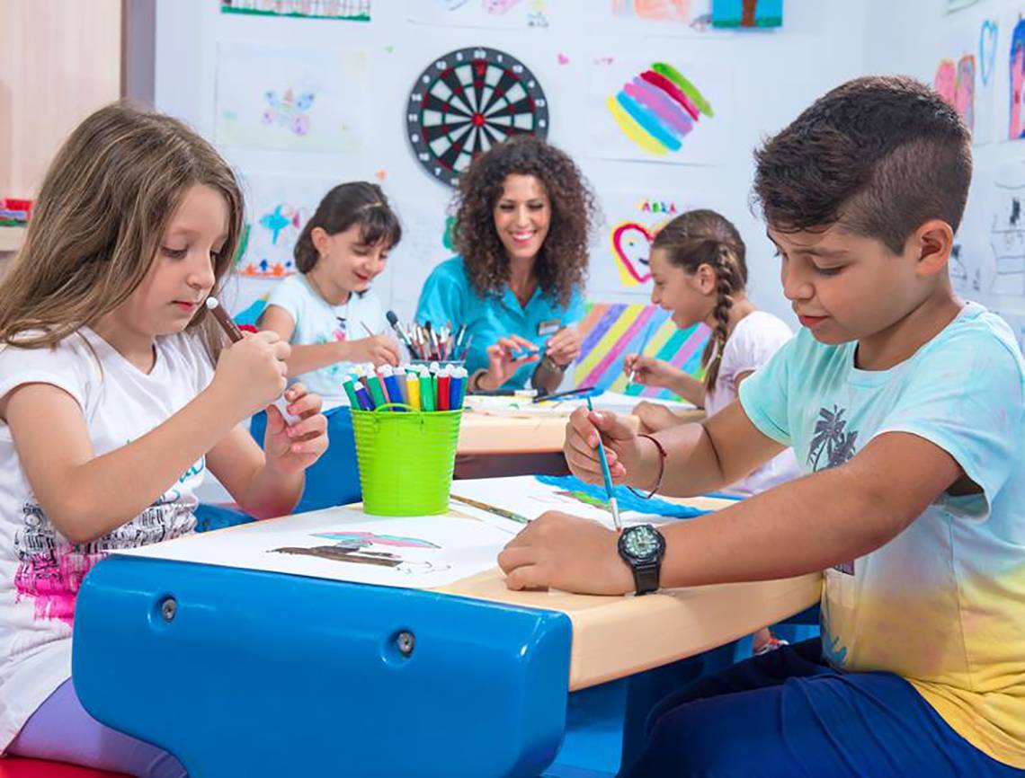 Kinder sitzen an einem Tisch und zeichnen im Blue Bay Resort.