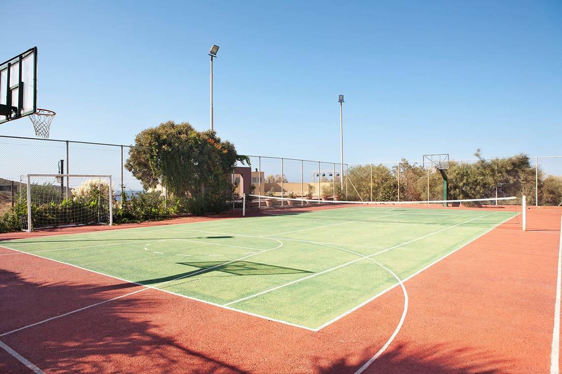 Freiluft-Basketballplatz des Blue Bay Resort mit leerem Spielfeld und Schatten.