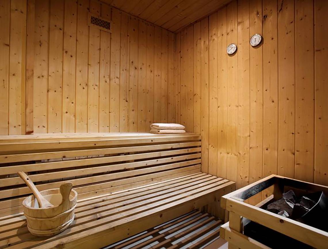 Saunaraum im Blue Bay Resort mit Holzbänken, Handtüchern und Holzeimern.