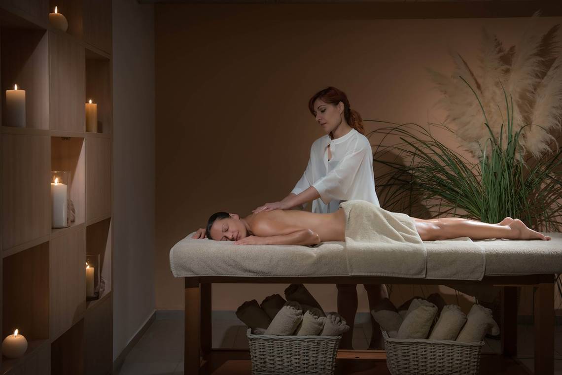 Massage im Blue Bay Resort mit Frau, die Rückenmassage gibt.