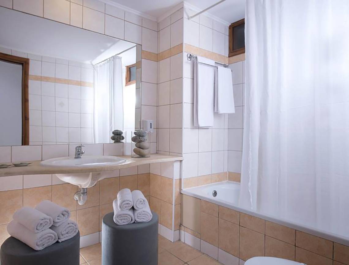 Ein Badezimmer im Blue Bay Resort mit Badewanne, Dusche, Spiegel und Handtüchern.