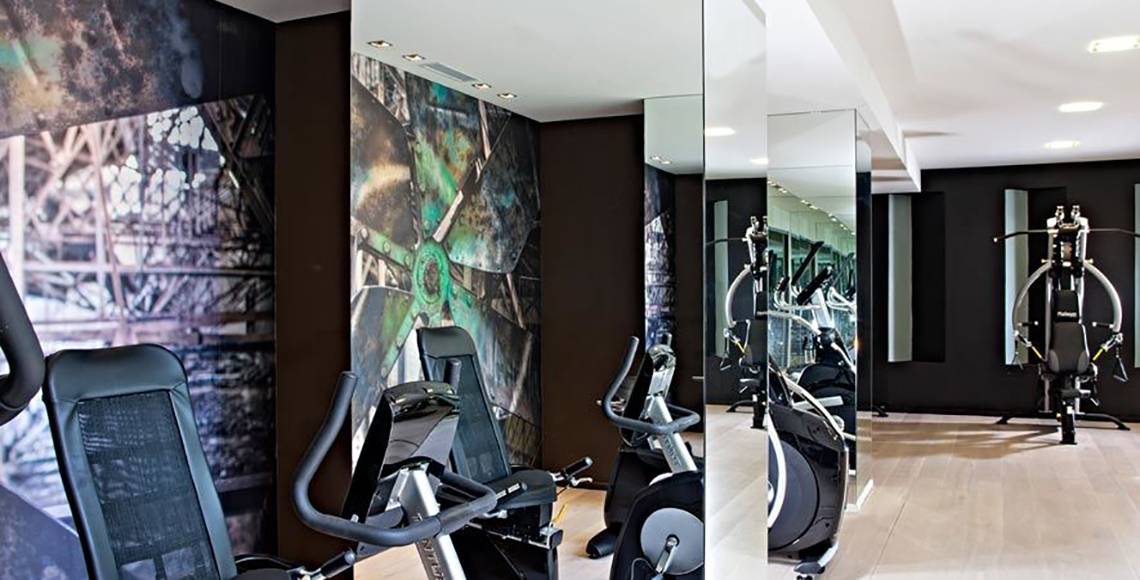 Fitnesscenter im Aqua Blu Boutique Hotel & Spa mit modernen Trainingsgeräten und Spiegelwänden.