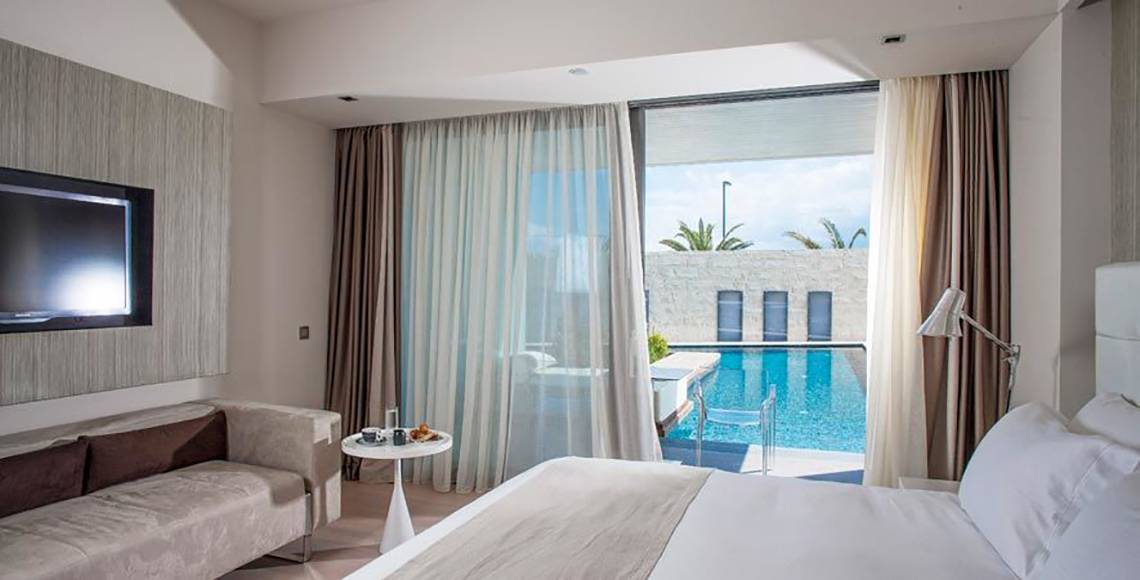 Innenansicht eines Zimmers im Aqua Blu Boutique Hotel & Spa mit Blick auf den Pool.
