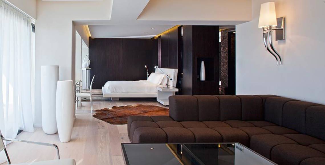 Schlafzimmer im Aqua Blu Boutique Hotel mit Bett, Couch, Teppich und Dekorationsgegenständen.