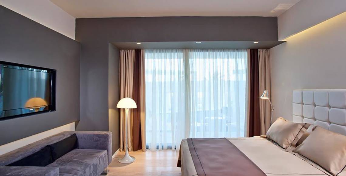 Hotelzimmer des Aqua Blu Boutique Hotel & Spa mit Fernseher, Lampe, Bett und Couch