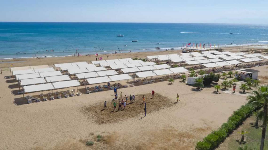 Luftaufnahme des Royal Alhambra Palace Strands mit Volleyballplatz und vielen Sonnenschirmen