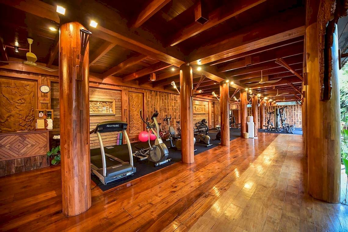 Fitnesscenter im Santhiya Koh Phangan Resort & Spa mit Holzboden und Trainingsgeräten